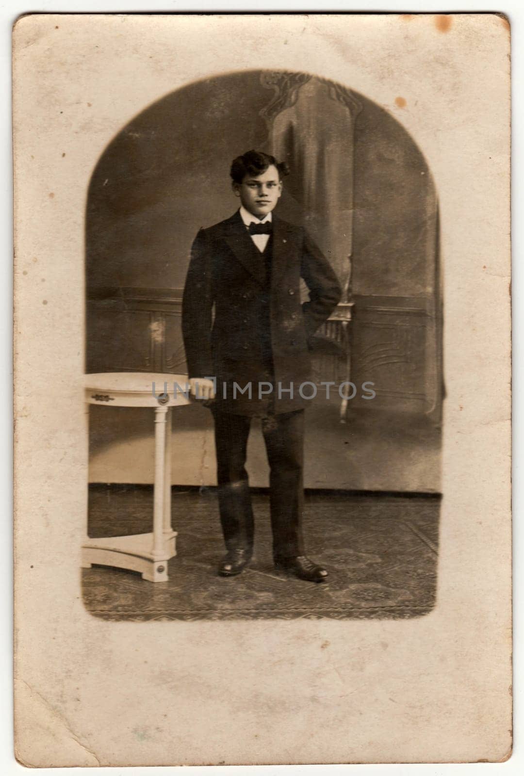 Vintage photo shows a young boy poses in a photography studio. Retro black and white photography. by roman_nerud