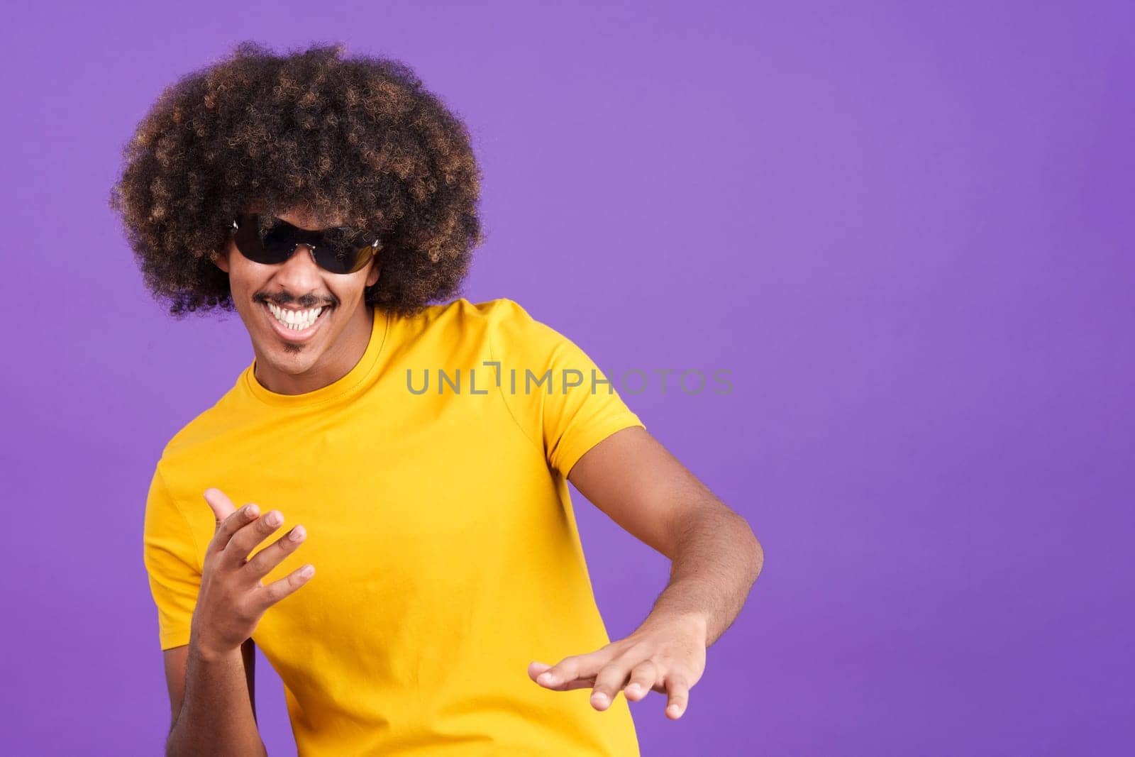 Cool african man with curly hair rapping in sunglasses in studio