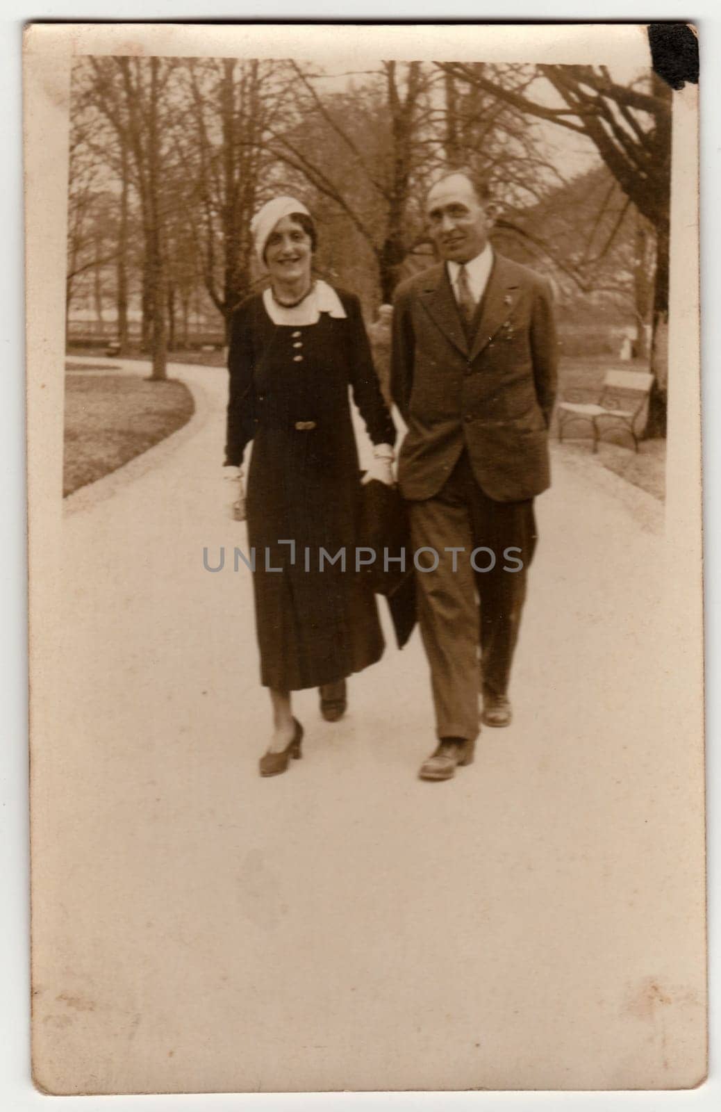 Vintage photo shows a couple goes for a walk in the city park. Retro black and white photography. by roman_nerud