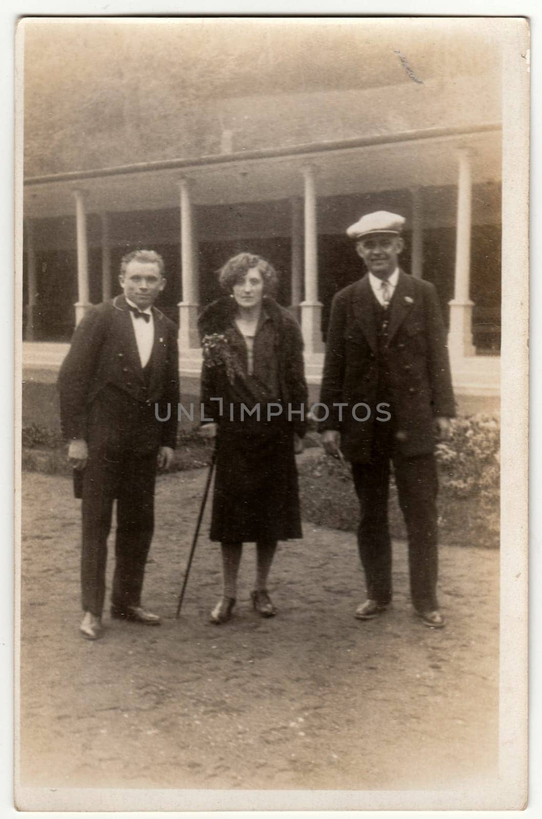 Vintage photo shows two men and woman pose outside. Original retro black and white photography. by roman_nerud