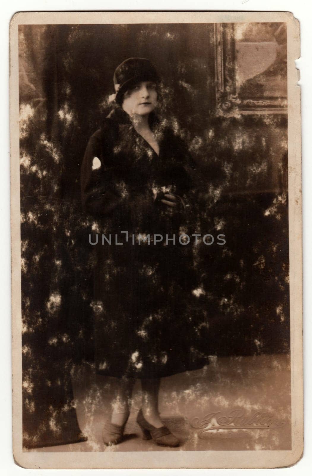 KRALUV DVUR, THE CZECHOSLOVAK REPUBLIC - CIRCA 1930s: Vintage photo shows woman pose in a photography studio. Original retro black and white photography. With original film grain, blur and scratches.