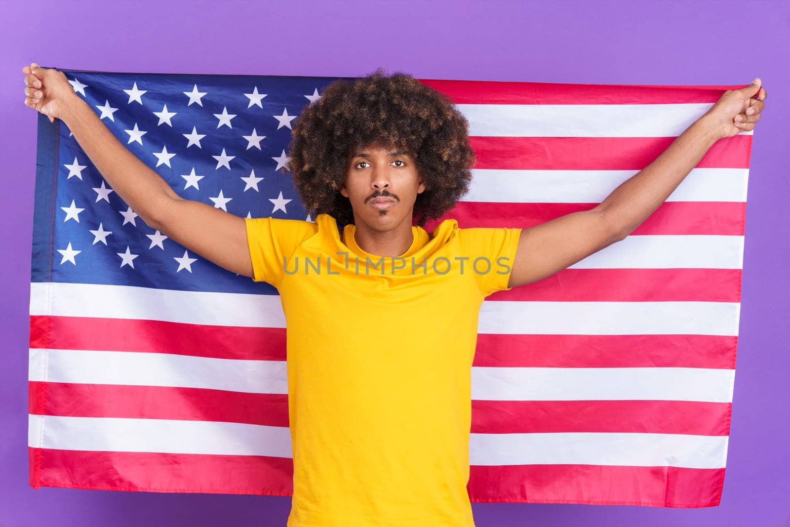 Serious african man raising a north america national flag by ivanmoreno