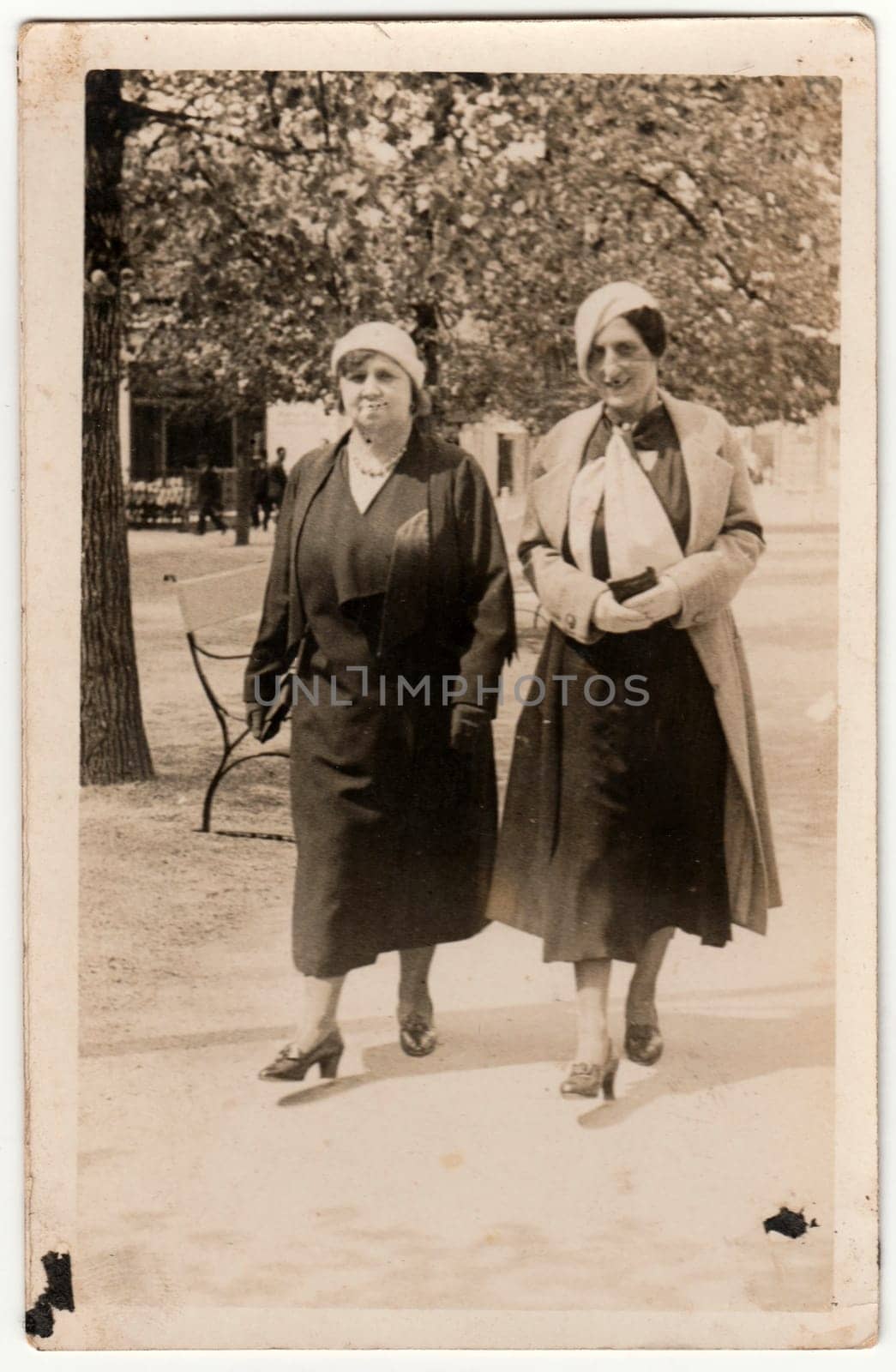 Vintage photo shows women go for a walk in the city park. Original retro black and white photography by roman_nerud