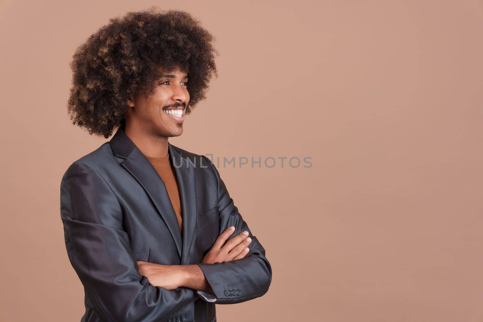 Smiley stylish african man with a black jacket crossing the arms in studio
