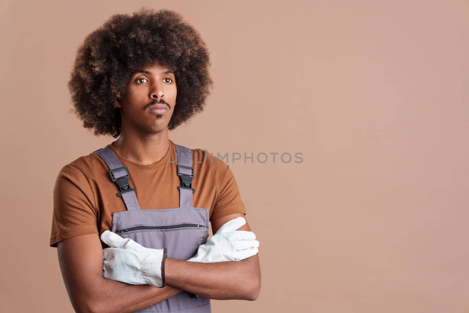 Serious african man carpentry worker with tools and work uniform in studio