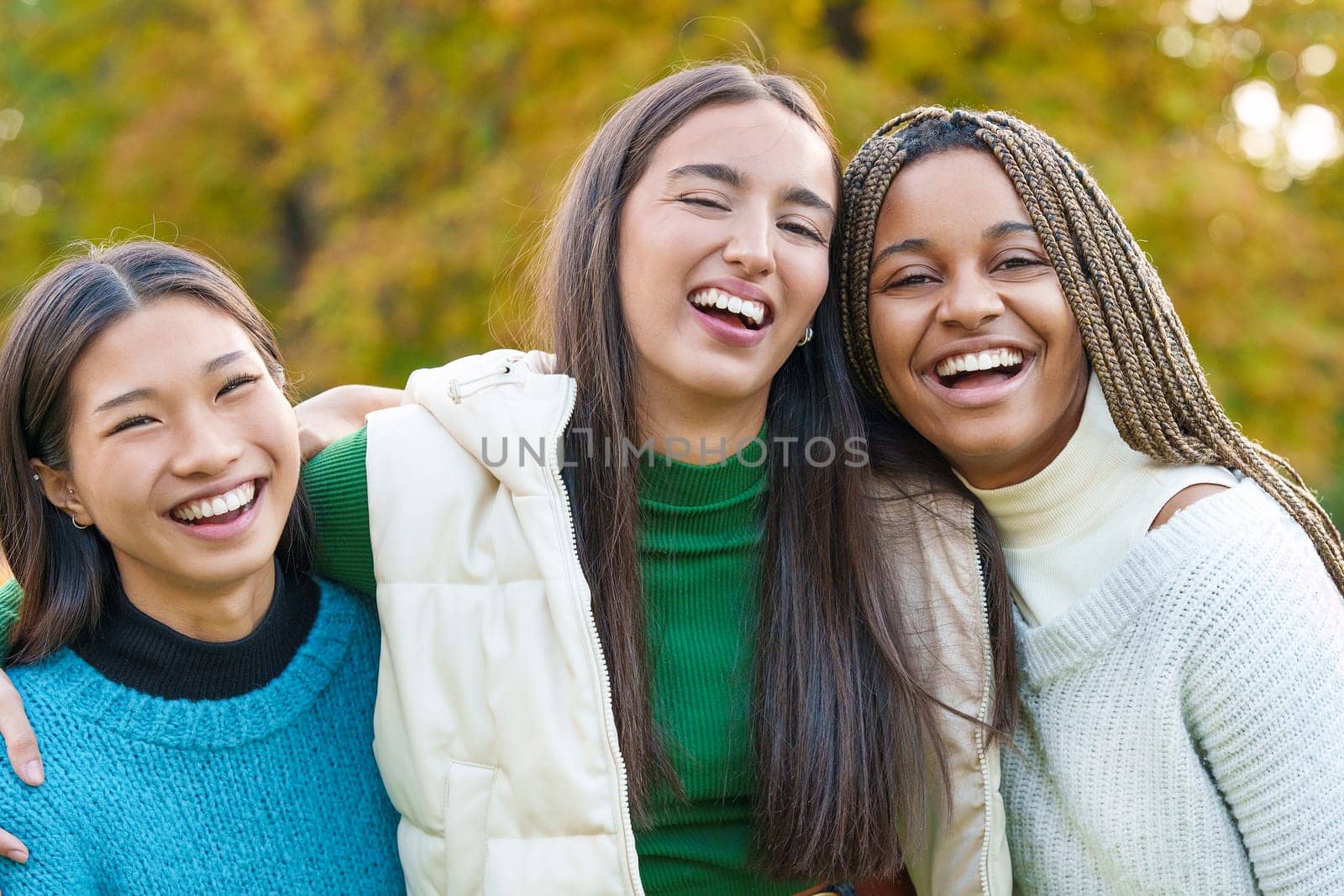 Multiethnic female friends embracing while having fun in the park