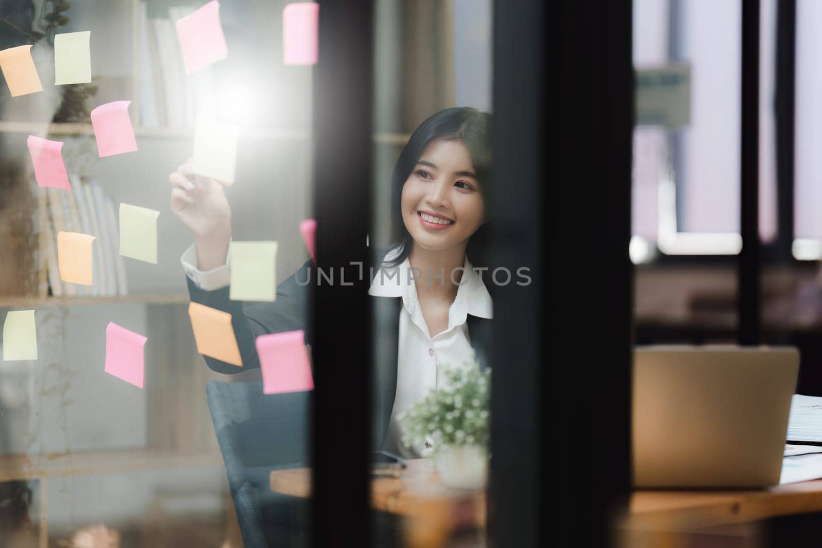 Beautiful asian business woman working with sticky note at office. Financial analysis and tax concept by itchaznong