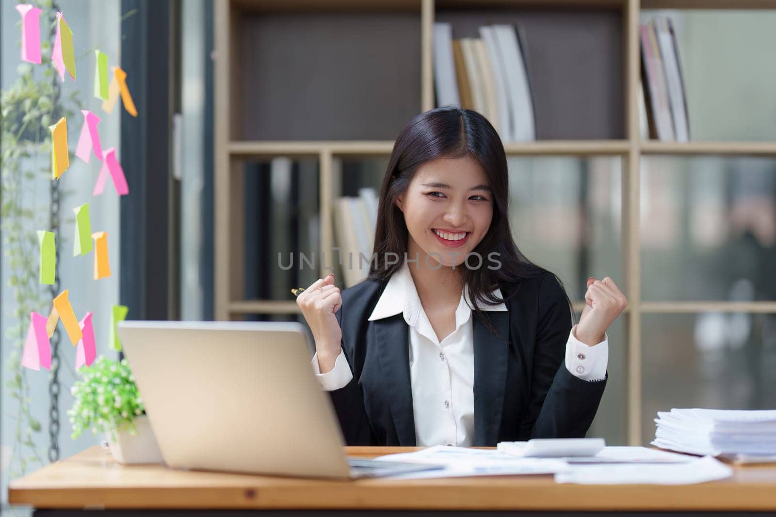 Asian Businessperson using laptop and celebrating victory and success, have good news, job celebrating achievement. by itchaznong