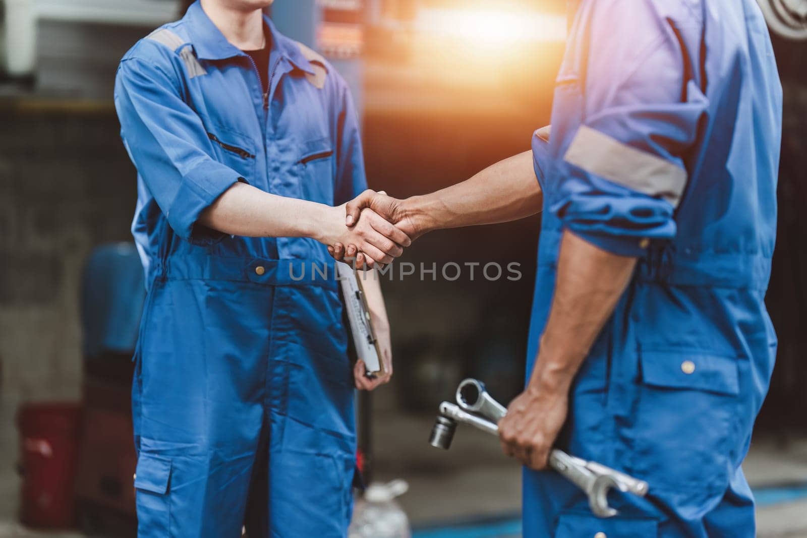 Expert auto mechanic handshake and working together at garage. automobile car concept by itchaznong