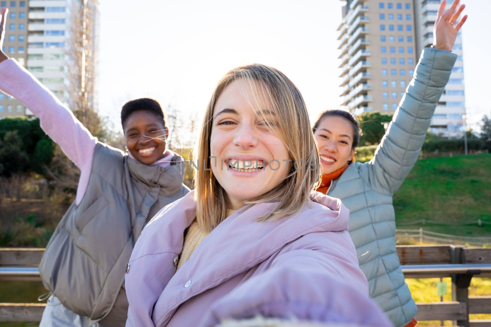 Three diverse girls taking a selfie portrait with smartphone. Friendship multi-ethnic real people. by PaulCarr