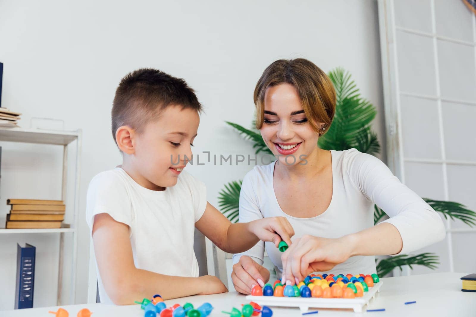 educational games for children a child psychologist is engaged in a color mosaic with a boy in the office