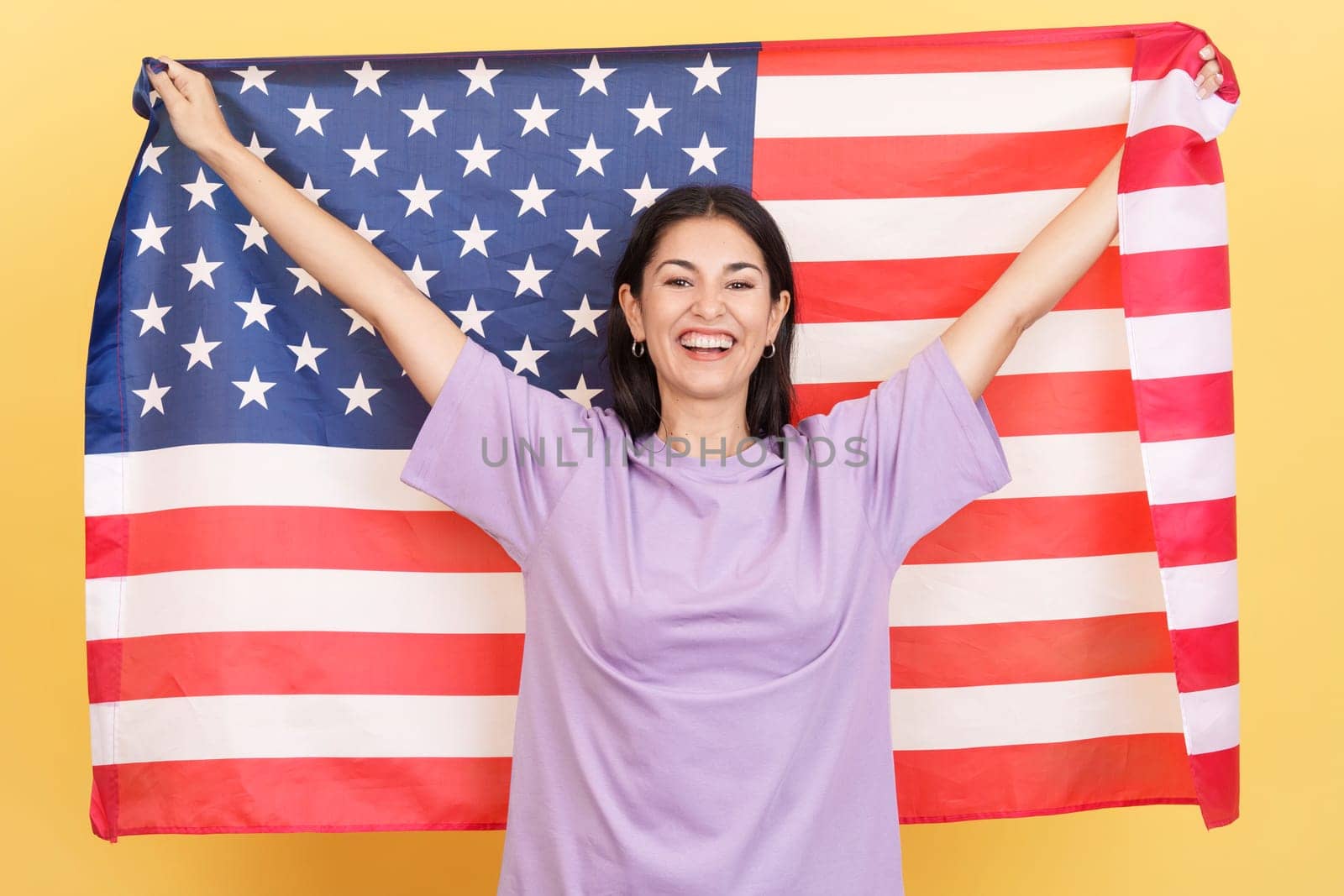 Happy caucasian woman raising a north america national flag by ivanmoreno