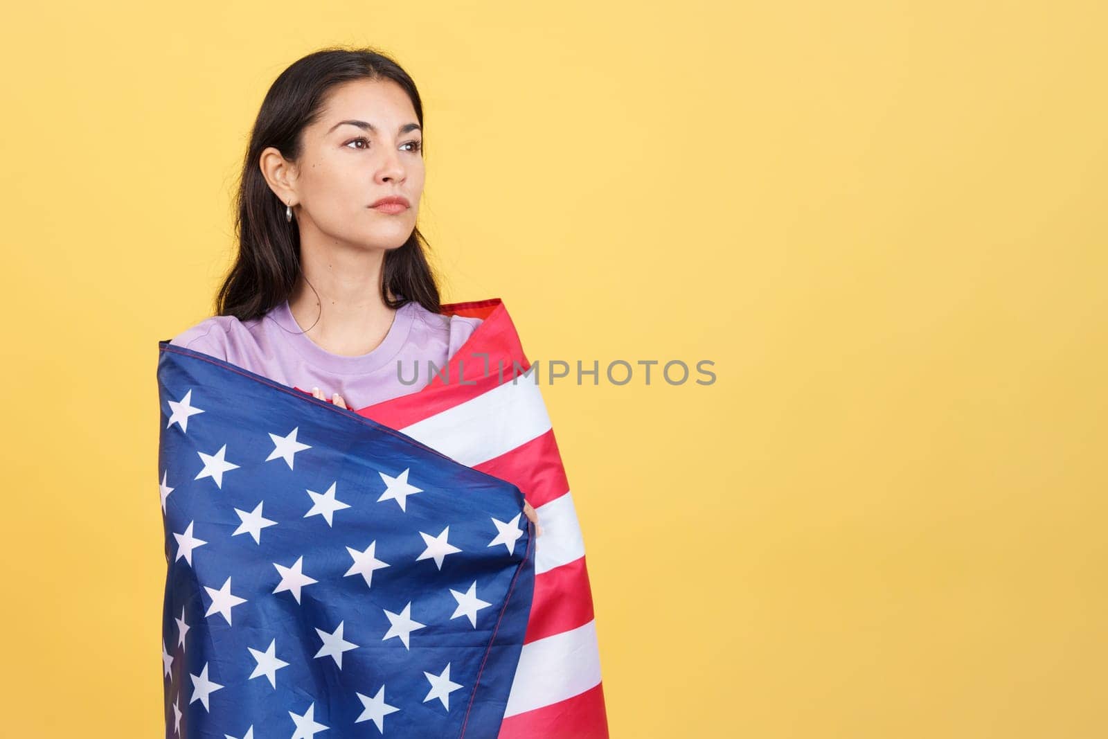 Proud woman wrapping with a north america national flag by ivanmoreno