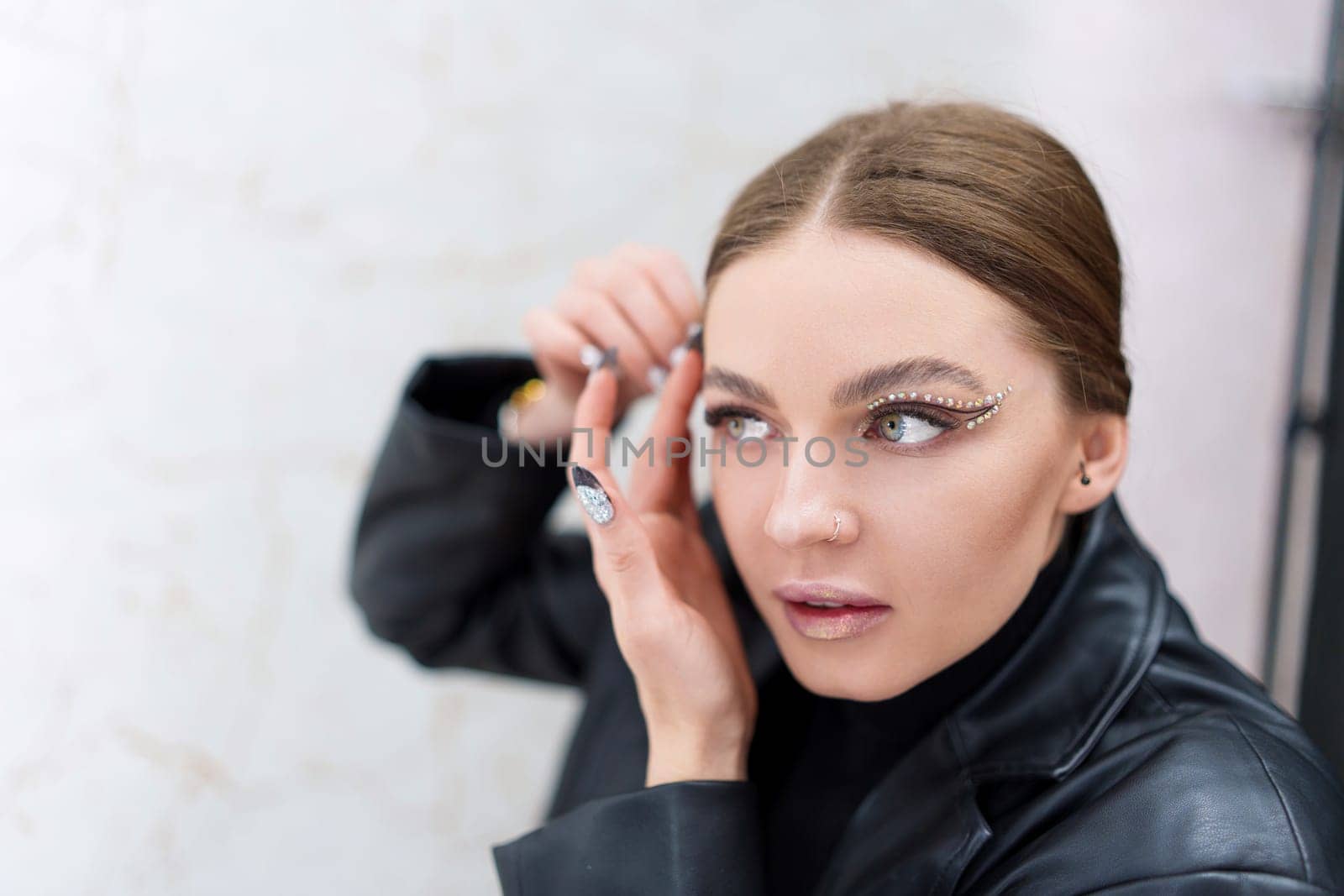 Concentrated caucasian beauty woman applying instant invisible stickers to the face on a backstage