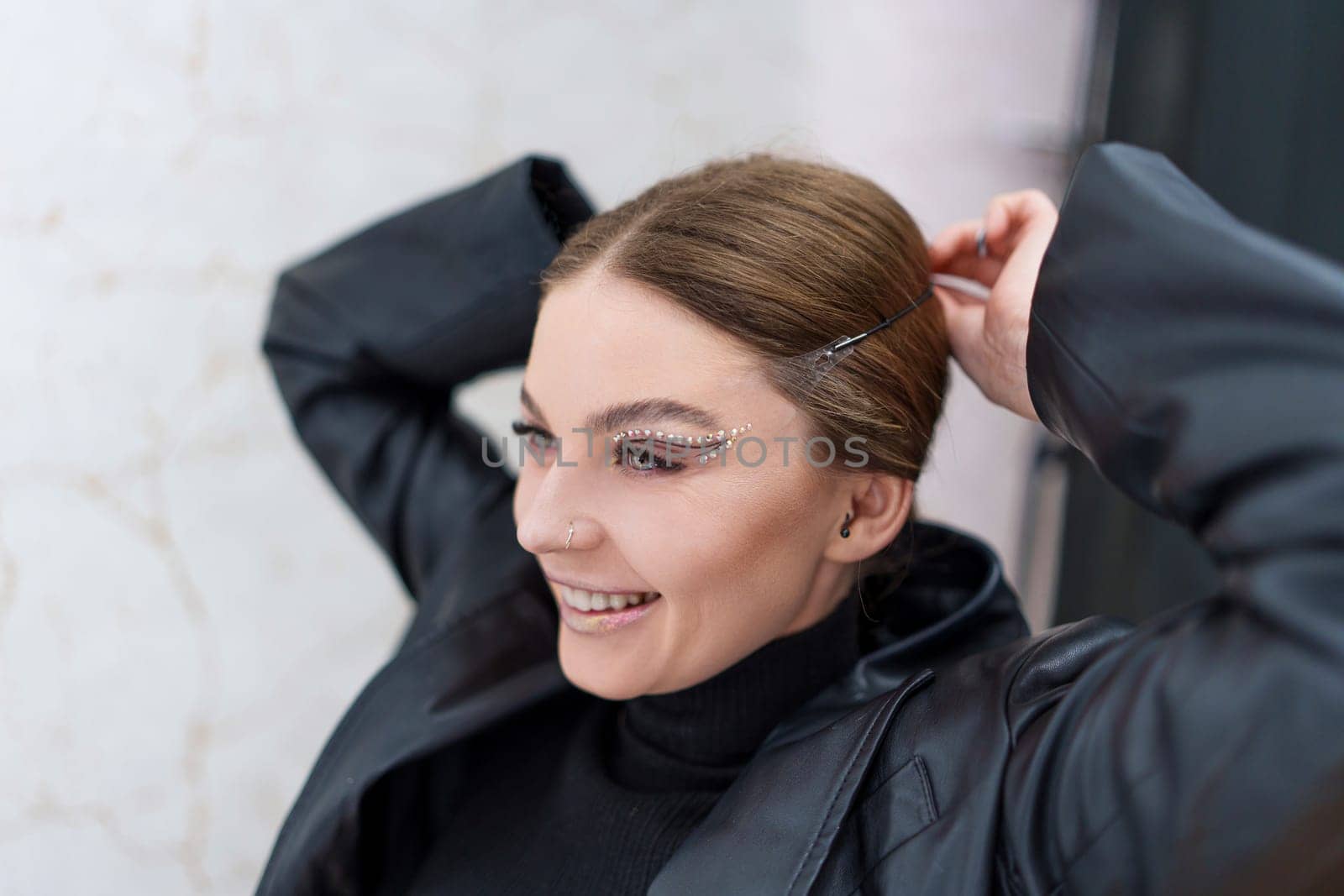 Happy caucasian beauty woman applying instant invisible stickers to the face on a backstage