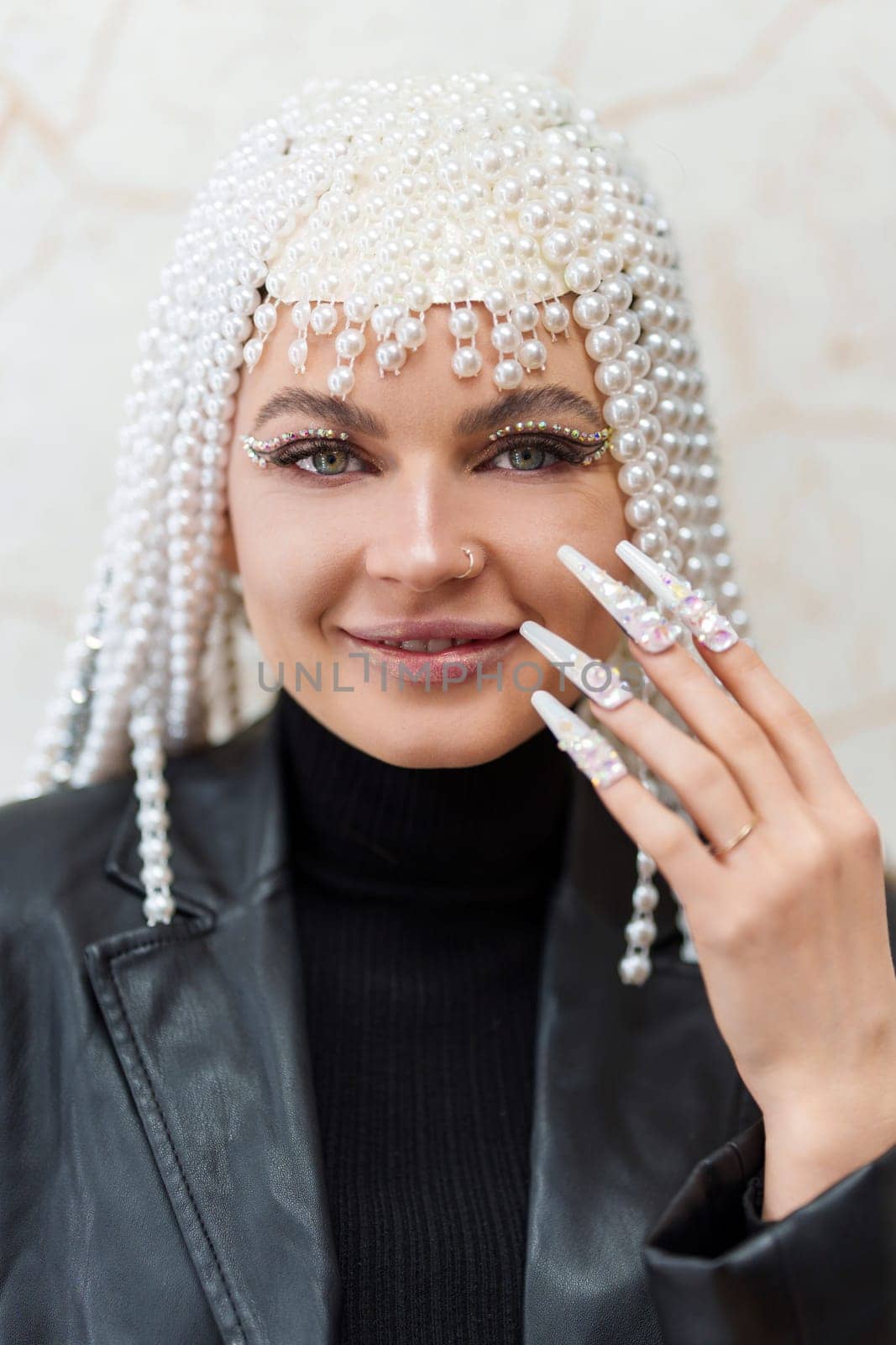 Vertical close up portrait of an artist with a wig of pearls, glitter and fake nails