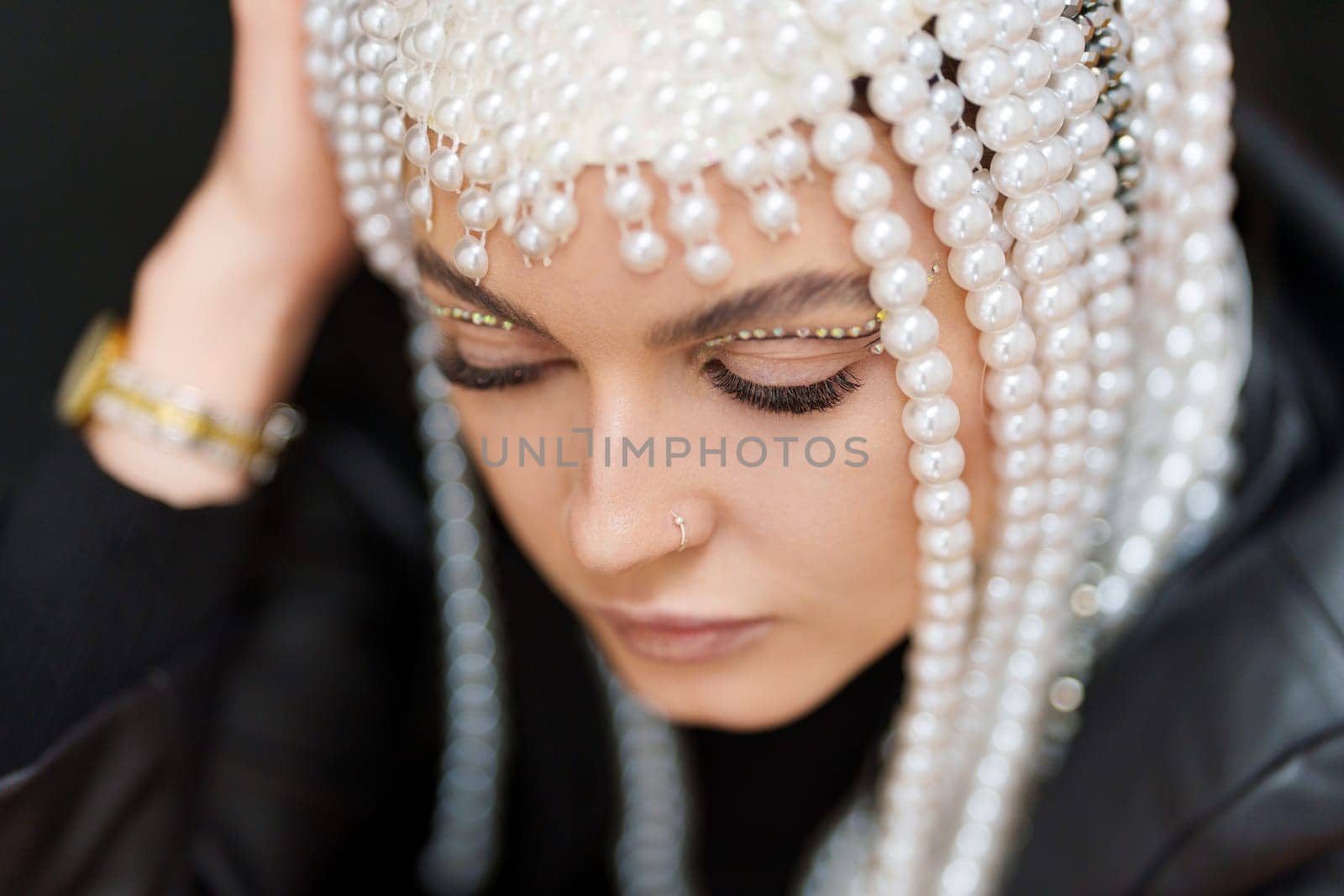 High angle view of a sensual woman with make up and a wig of pearls