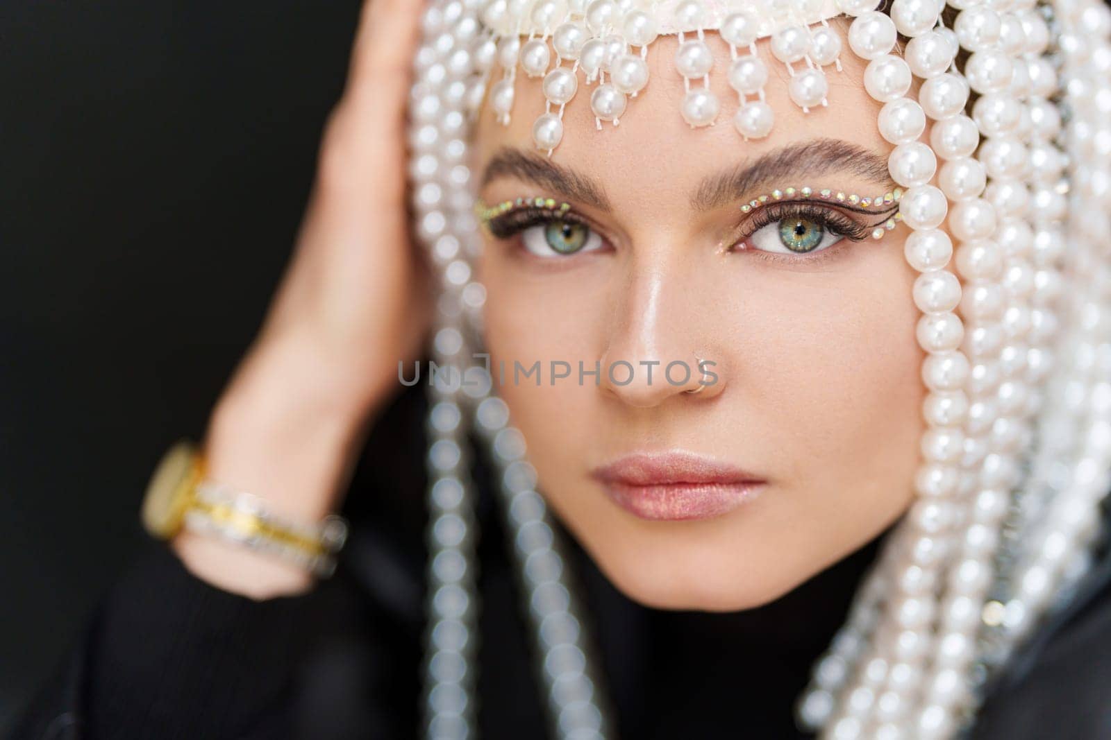 Close up portrait of a beauty caucasian sensual woman with make up and a wig of pearls