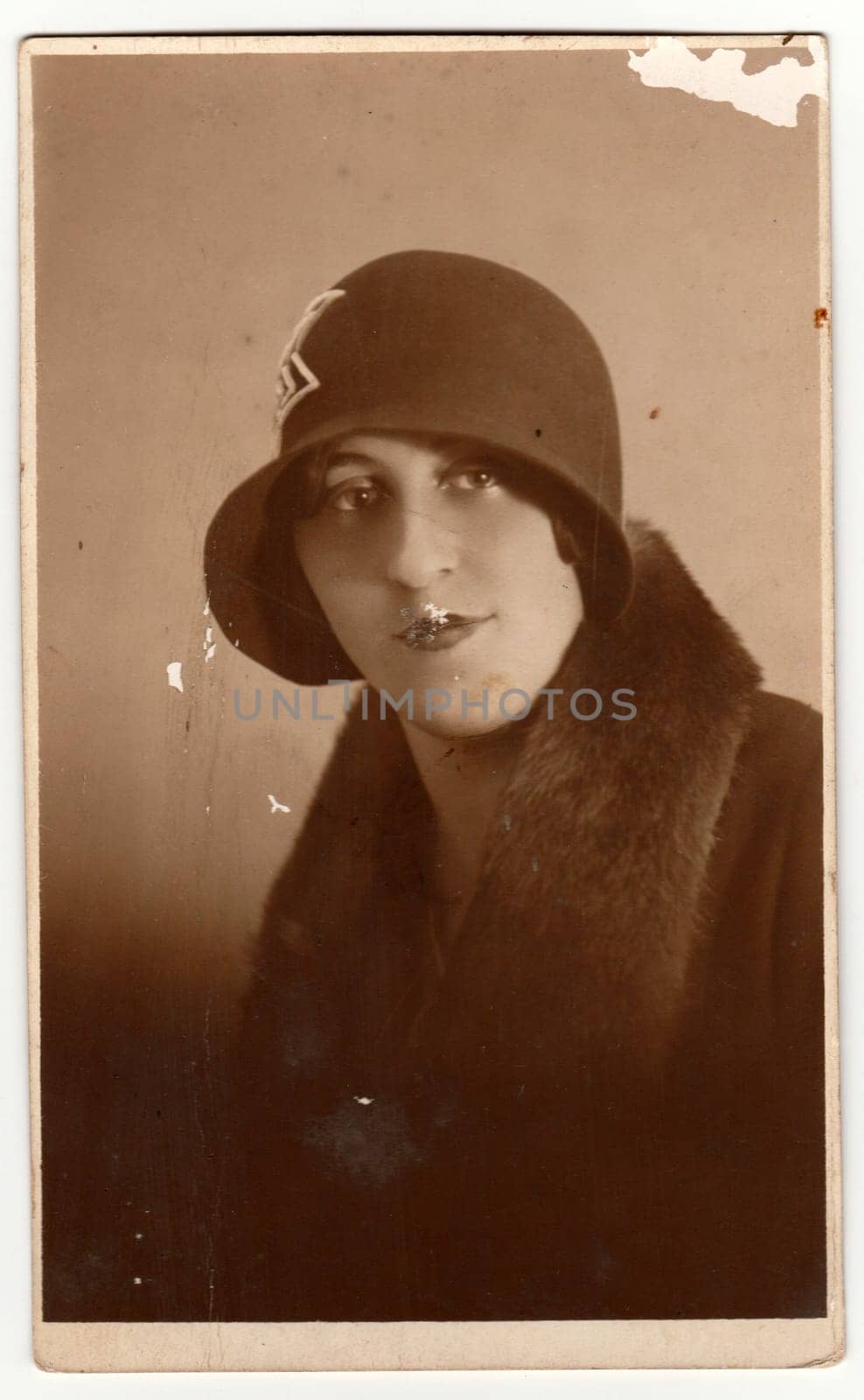 PRAGUE, THE CZECHOSLOVAK REPUBLIC - CIRCA 1930s: Vintage photo shows woman wears ladies hat - cloche hat and fur scarf. Retro black and white photography.