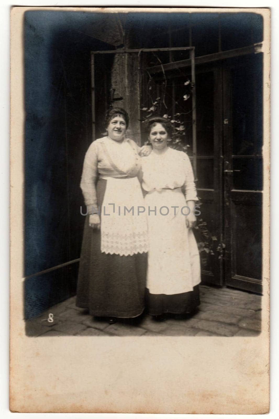 THE CZECHOSLOVAK REPUBLIC - CIRCA 1930s: Vintage photo shows two housekeepers pose outside - in the backyard. Retro black and white photography.