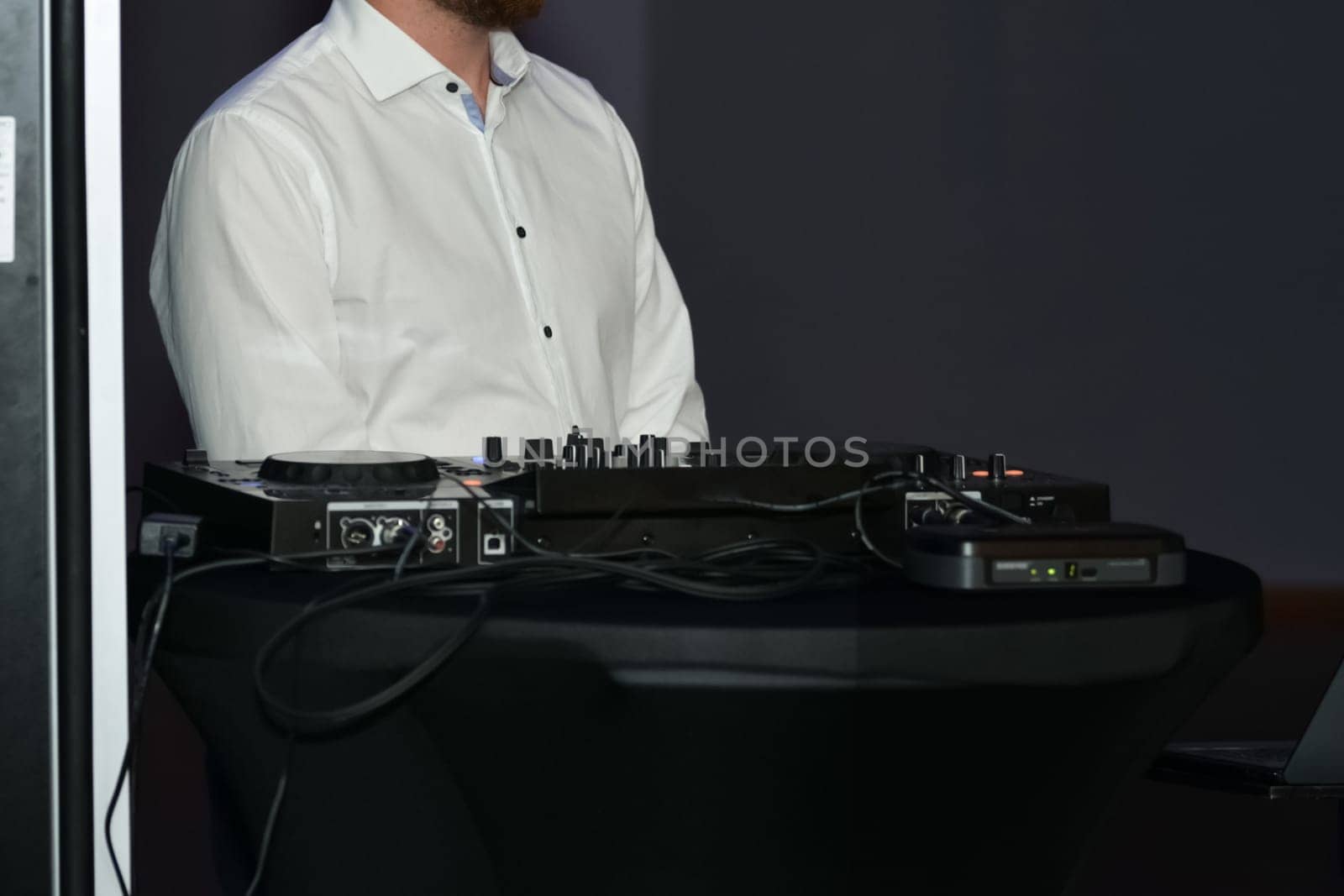 DJ in a white shirt and his equipment at a wedding