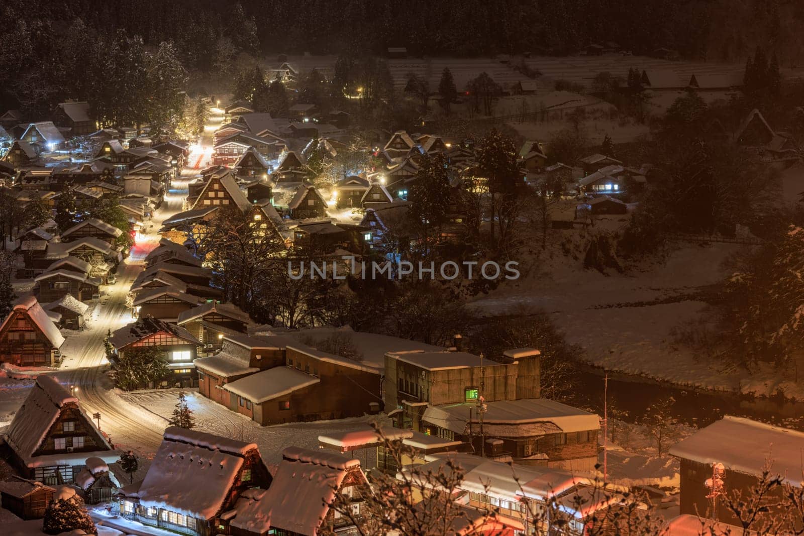 Traditional Japanese village amid trees and snow on misty winter night. High quality photo