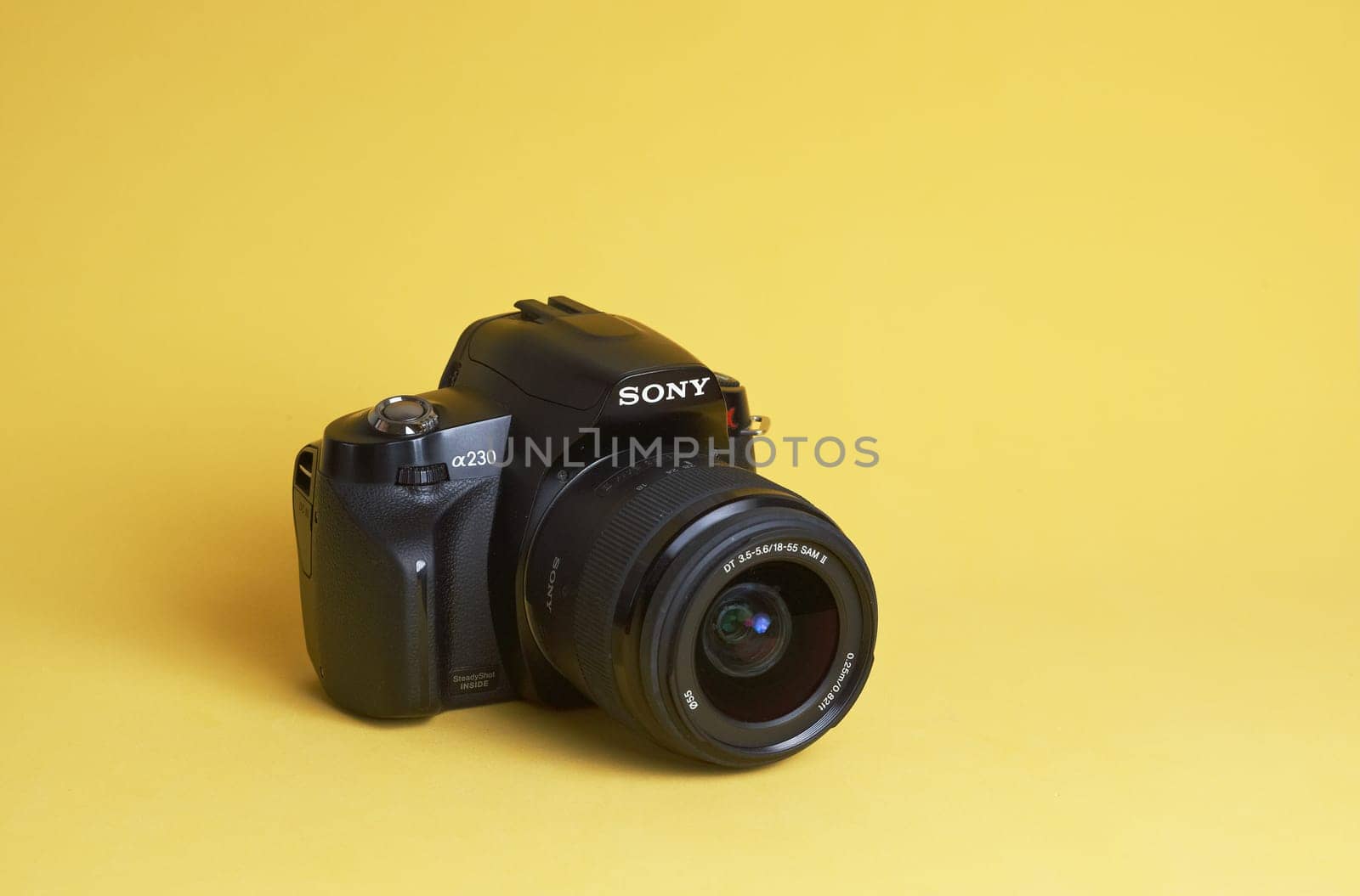 Seversk Russia, March 2023, the body of the Sony A65 Sony alpha full-frame mirrorless camera . Black body of the SLR camera on a yellow background