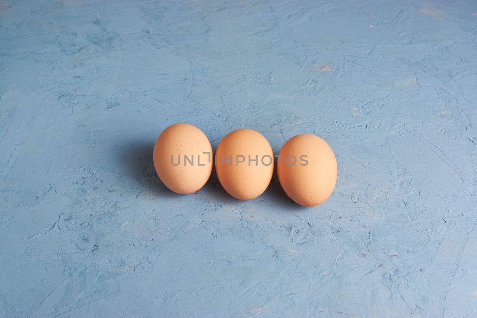 Three red Easter eggs on a blue background. Colorful decoration of Easter eggs. Flat position, top view. with a place to copy the text. Minimal idea for an Easter concept.