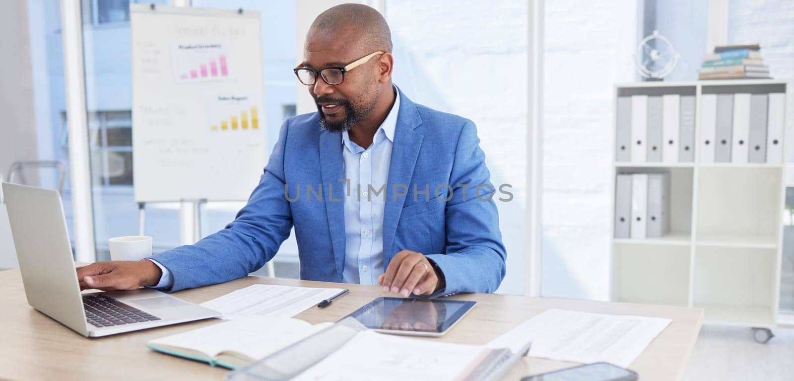 Black man, business and laptop for corporate planning, strategy or communication at the office desk. African American male CEO working on computer for company statistics, marketing or schedule tasks by YuriArcurs
