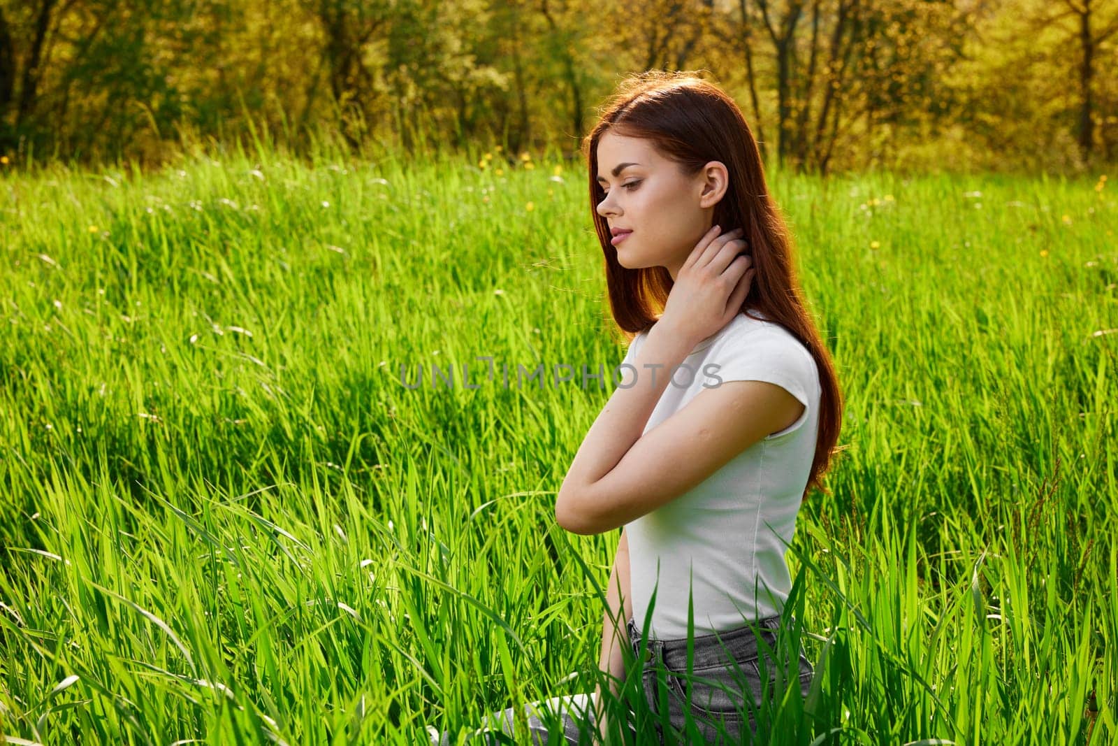cute, happy, carefree woman sitting in tall grass. High quality photo