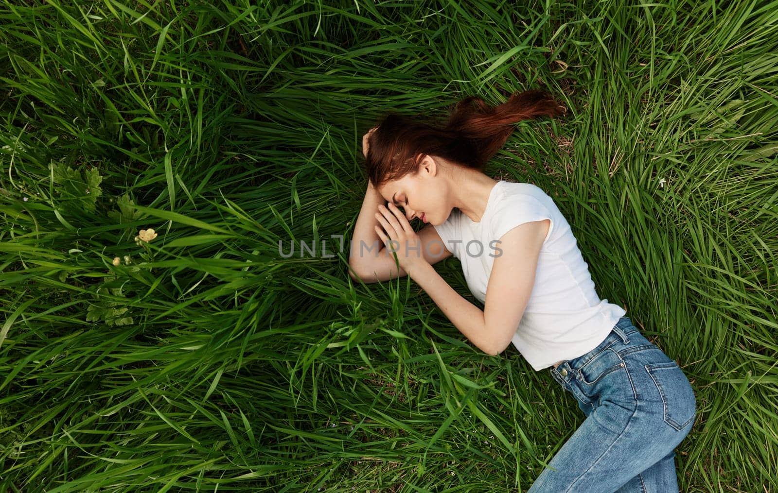 calm, peaceful woman falls asleep in tall grass by Vichizh