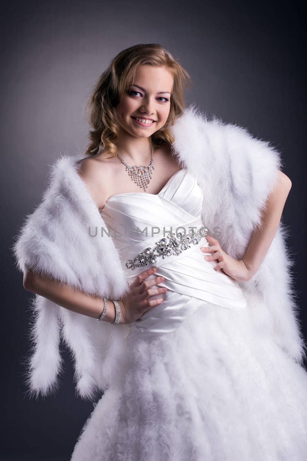 Portrait of beautiful smiling bride posing in studio