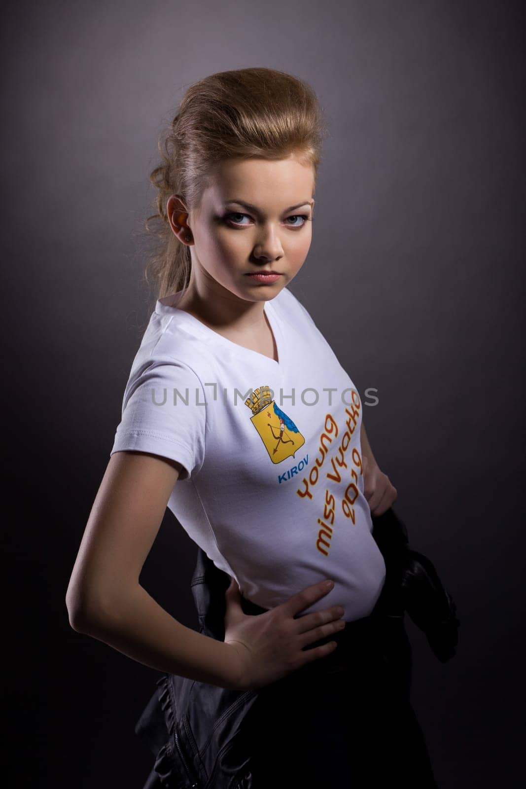 Portrait of attractive young girl in white t-shirt, on gray background