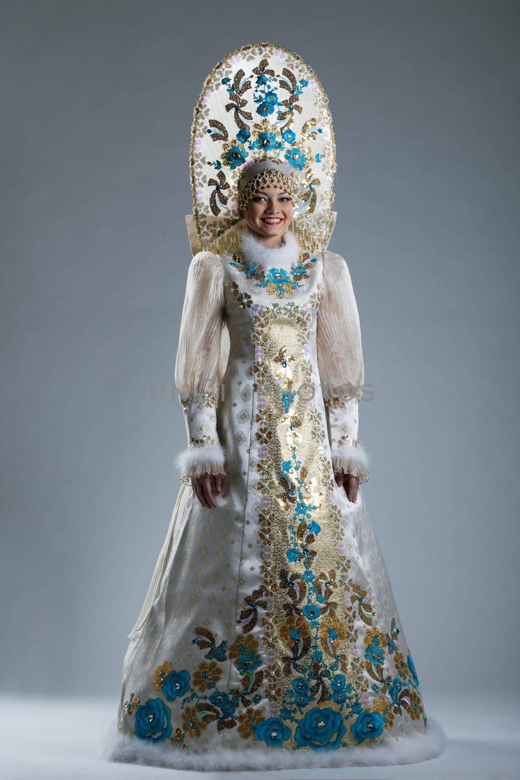 Smiling young girl posing in Russian traditional costume