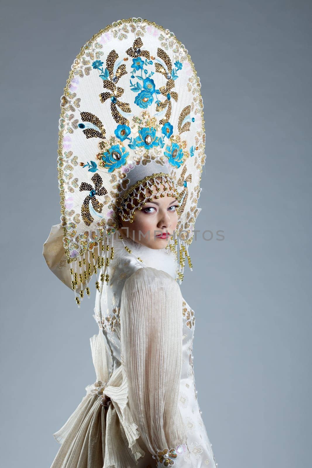 Image of beautiful Russian girl in kokoshnik, on blue background