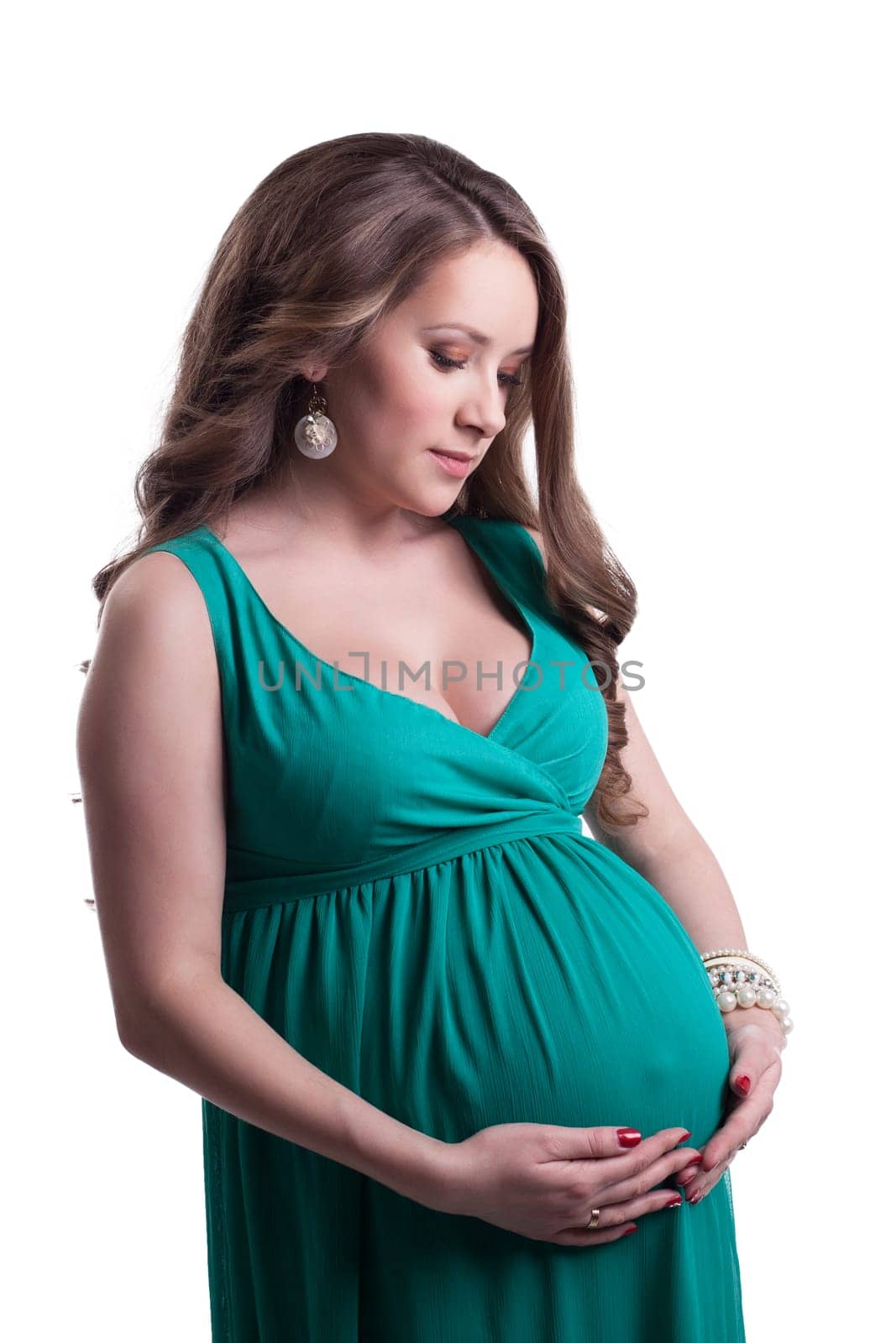 Beautiful pregnant woman posing in green dress, isolated on white