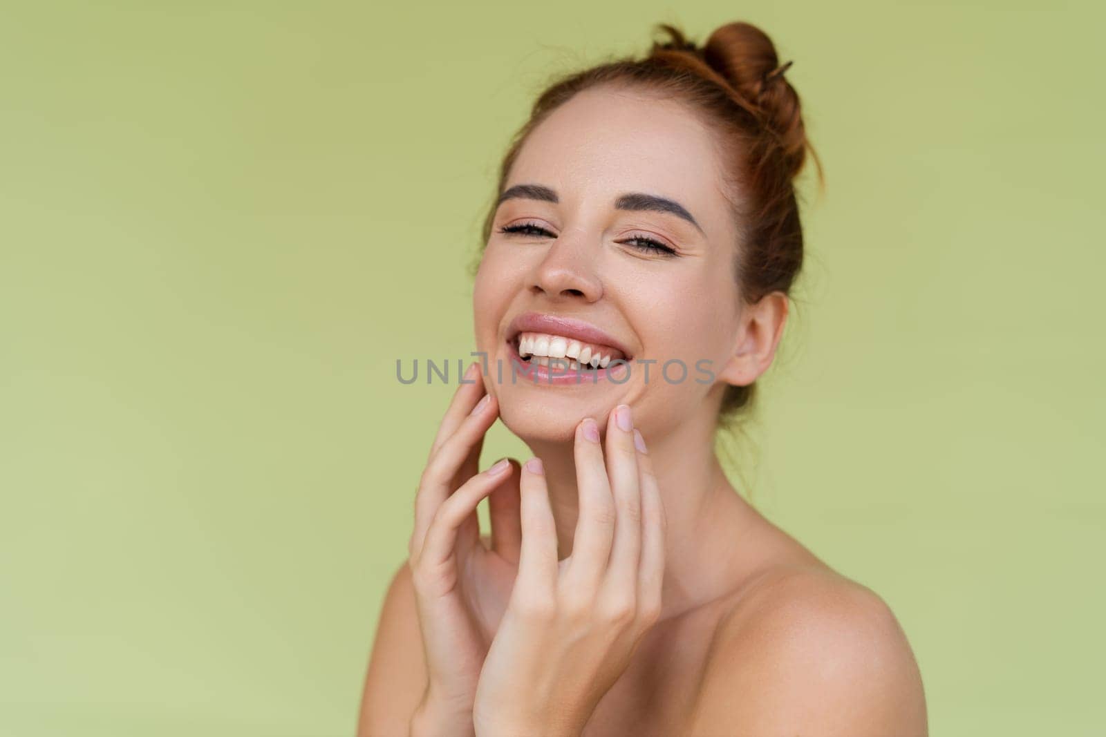 Beauty portrait of young topless red hair woman with bare shoulders on green background with perfect skin and natural makeup by kroshka_nastya