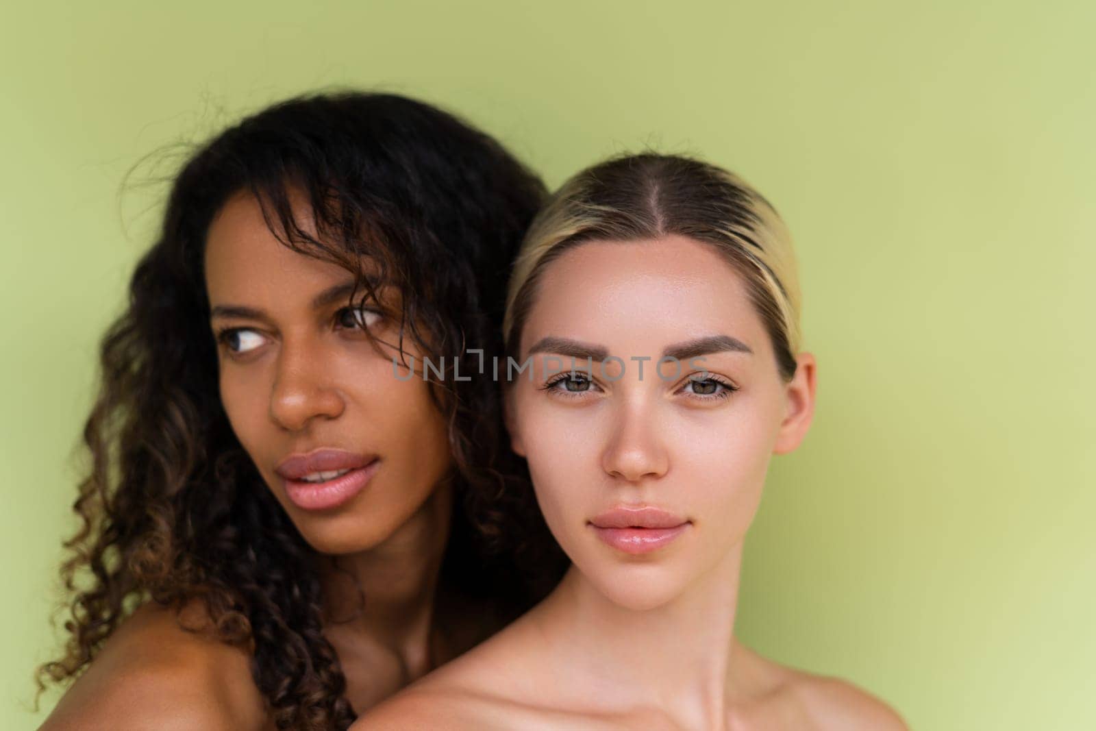 Woman close beauty portrait mixed race black skin and white skin, two female on green background by kroshka_nastya