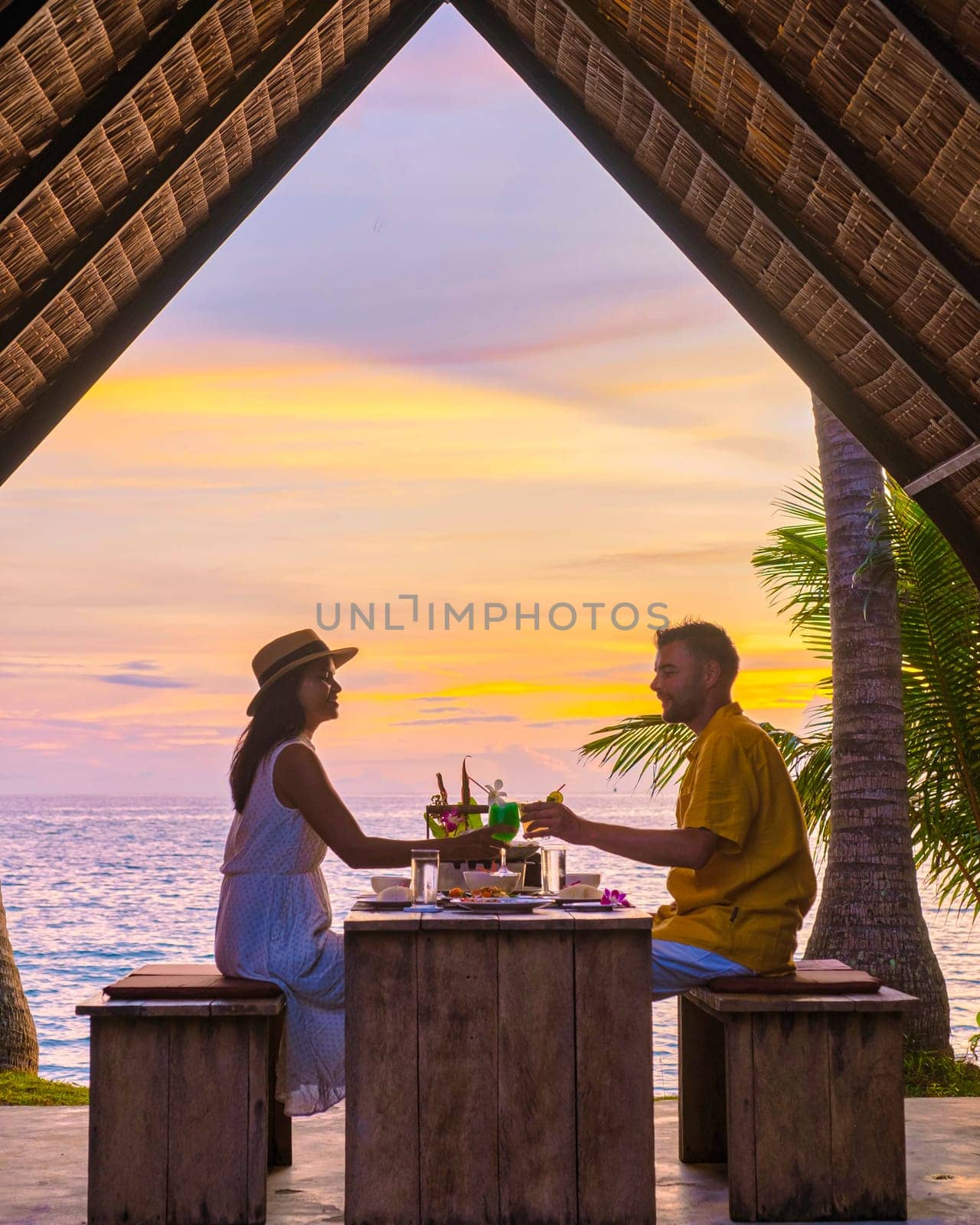 Couple having Romantic dinner on the beach with Thai food at sunset on the Island Koh Mak Thailand by fokkebok