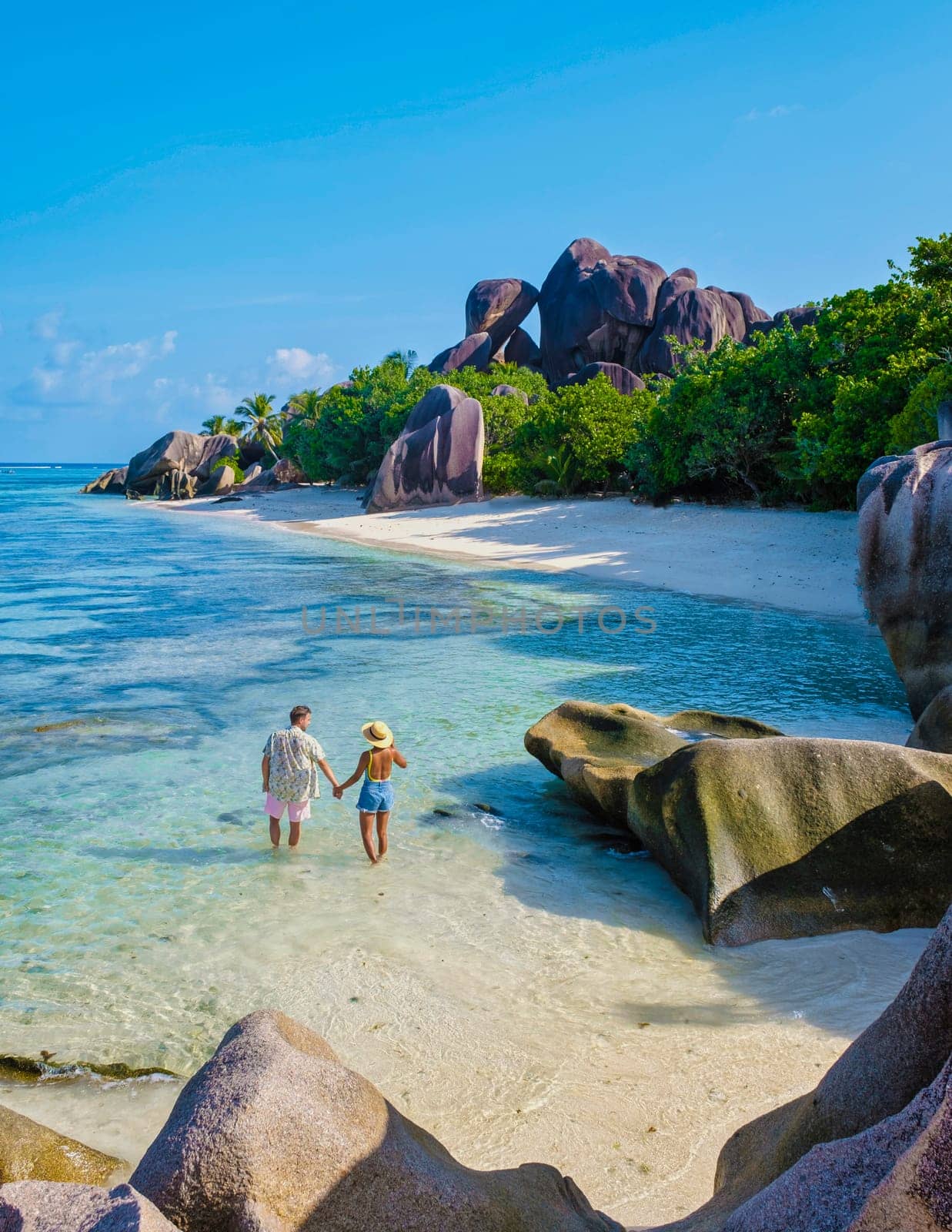 Anse Source d'Argent, La Digue Seychelles, a young couple of men and women on a tropical beach during a luxury vacation in Seychelles.