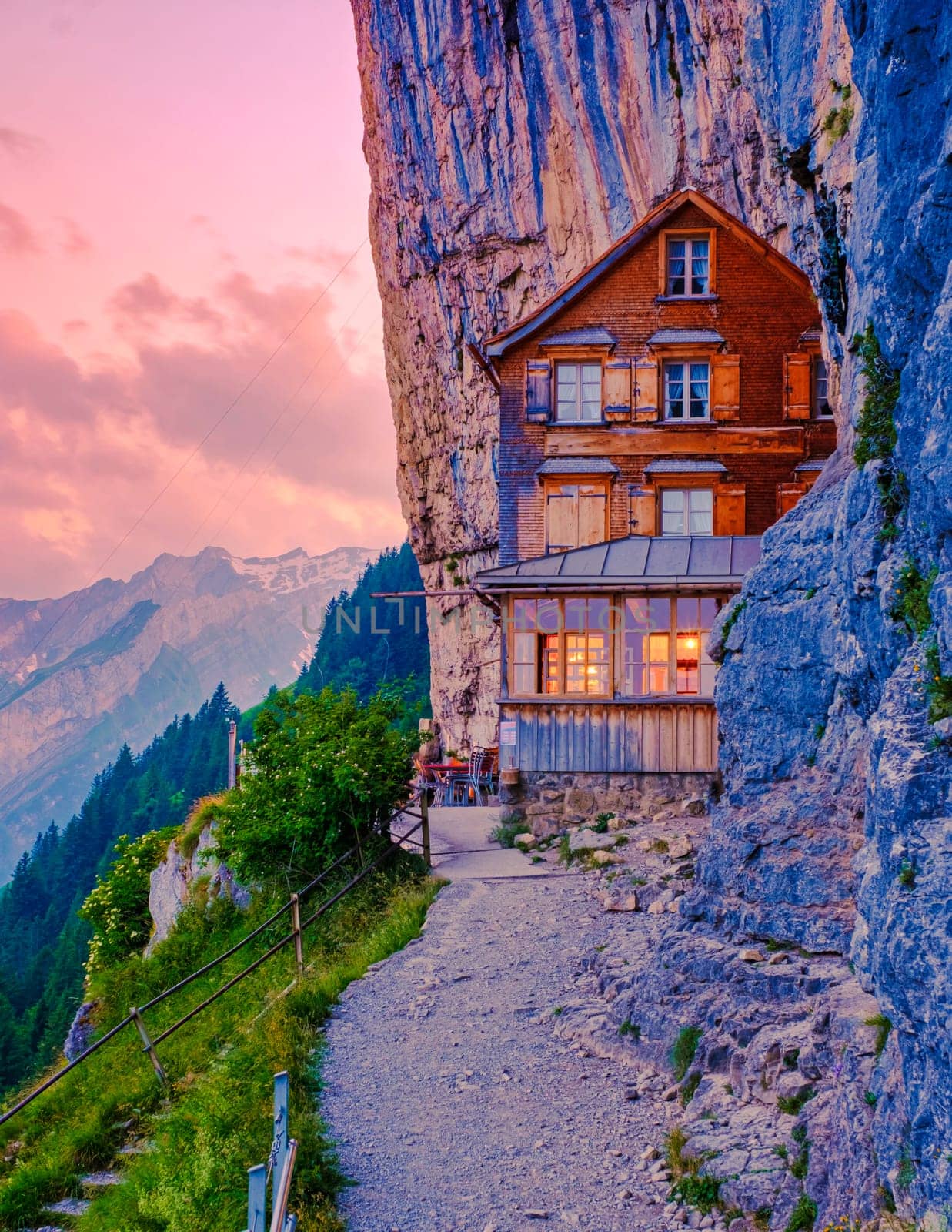 Berggasthaus Aescher in den Appenzeller Alpen at sunset, restaurant under a cliff on mountain Ebenalp in Switzerland, Appenzell during sunset in summer