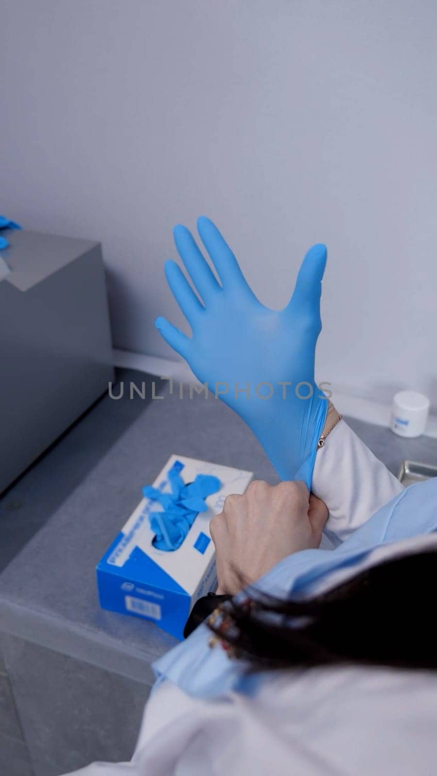 doctor or nurse worker surgeon preparing for the surgical operation and wearing hand gloves at health clinic or hospital office. Social distancing, quarantine for coronavirus