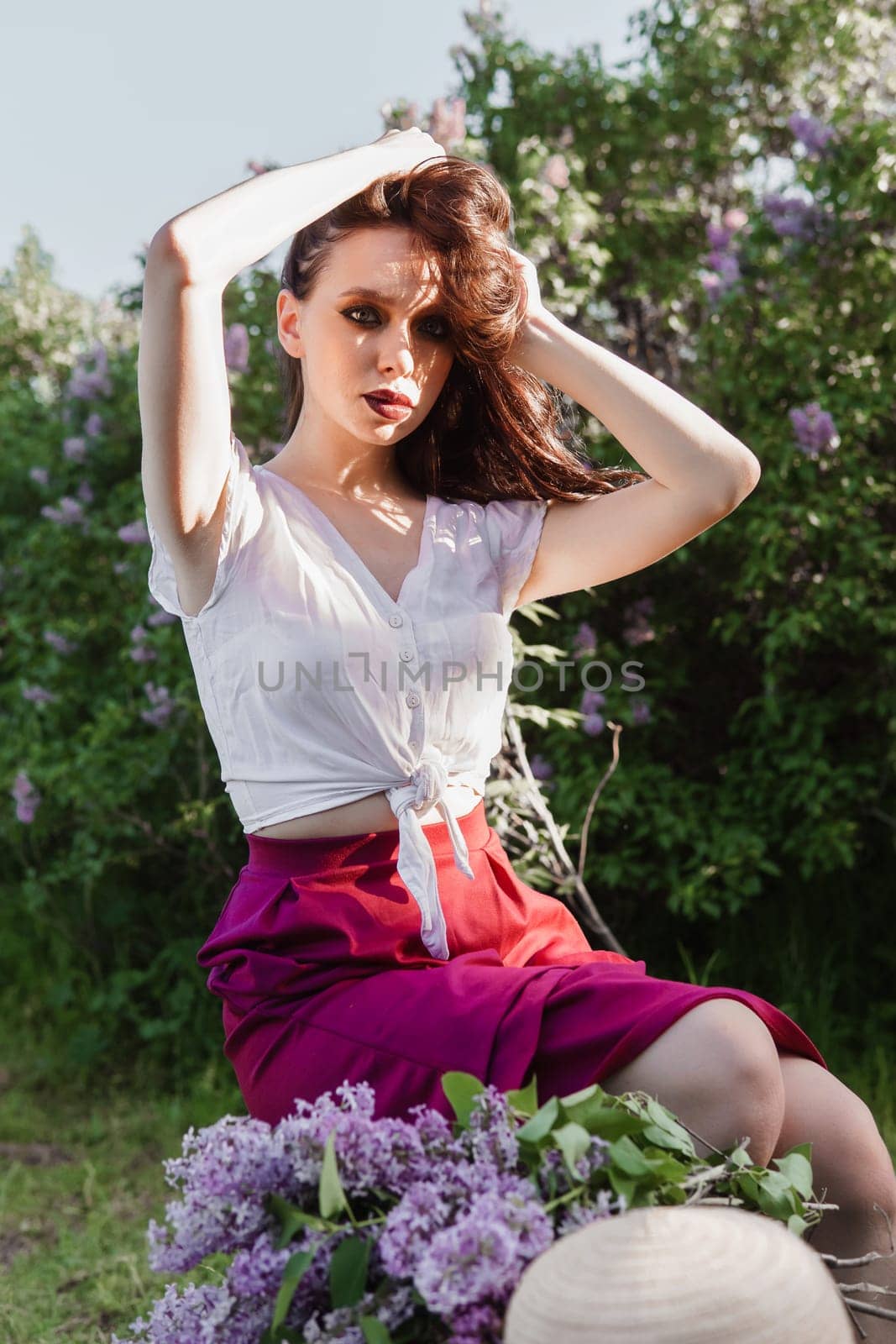 A fashionable girl with dark hair, a spring portrait in lilac tones in summer. Bright professional makeup