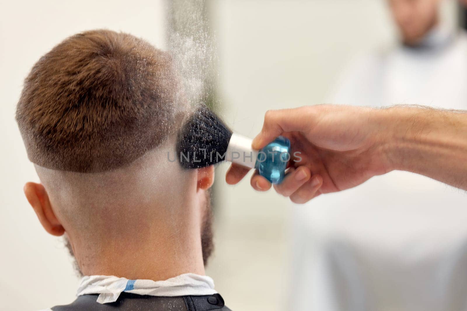 barber holding brush for talco in barber shop. close-up