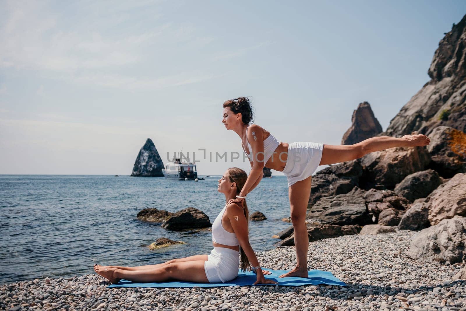 Woman sea yoga. Back view of free calm happy satisfied woman with long hair standing on top rock with yoga position against of sky by the sea. Healthy lifestyle outdoors in nature, fitness concept.