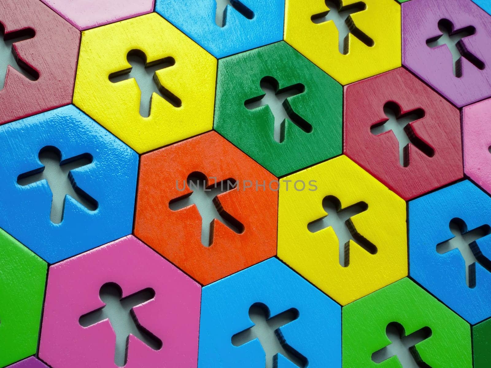 Multicolored figures on hexagonal plates. Allyship concept.