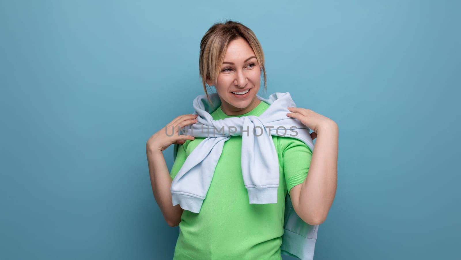 banner portrait of a positive bright girl in a casual outfit on a blue background with copy space by TRMK