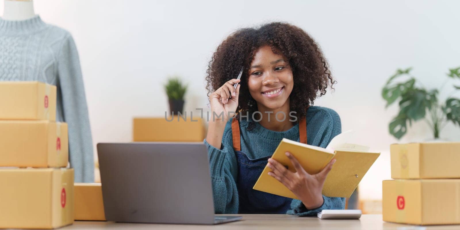 American African entrepreneur smile and checking online order. Successful SME entrepreneur concept.