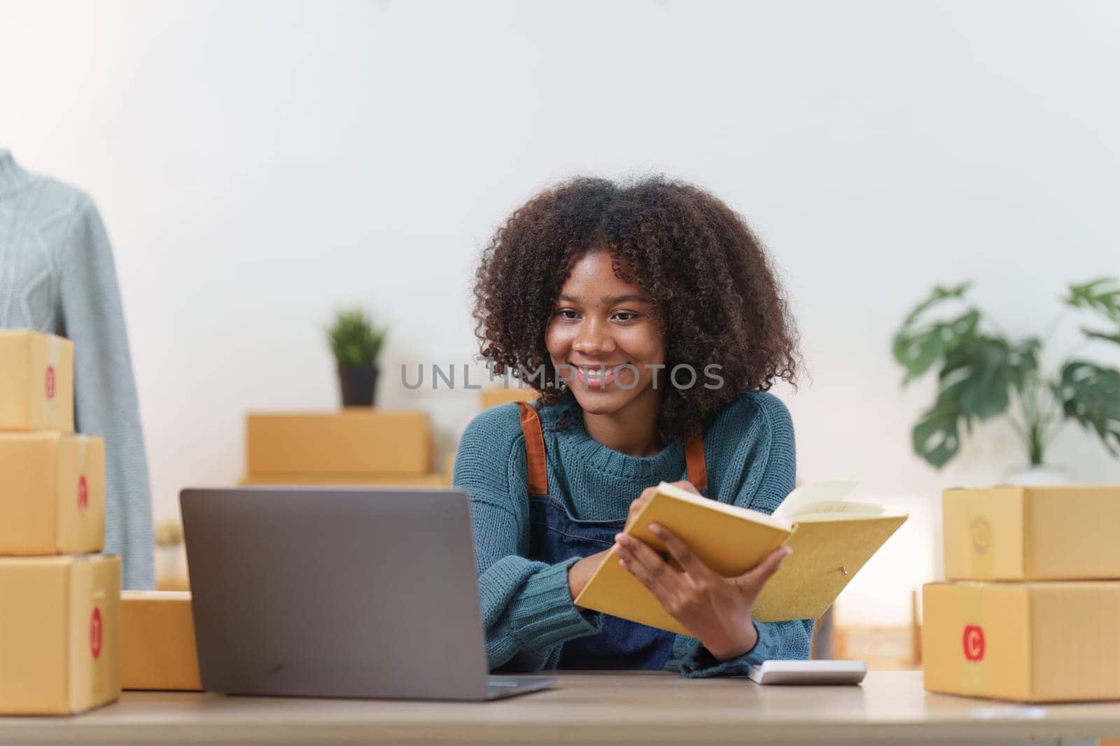 American African entrepreneur smile and checking online order. Successful SME entrepreneur concept.