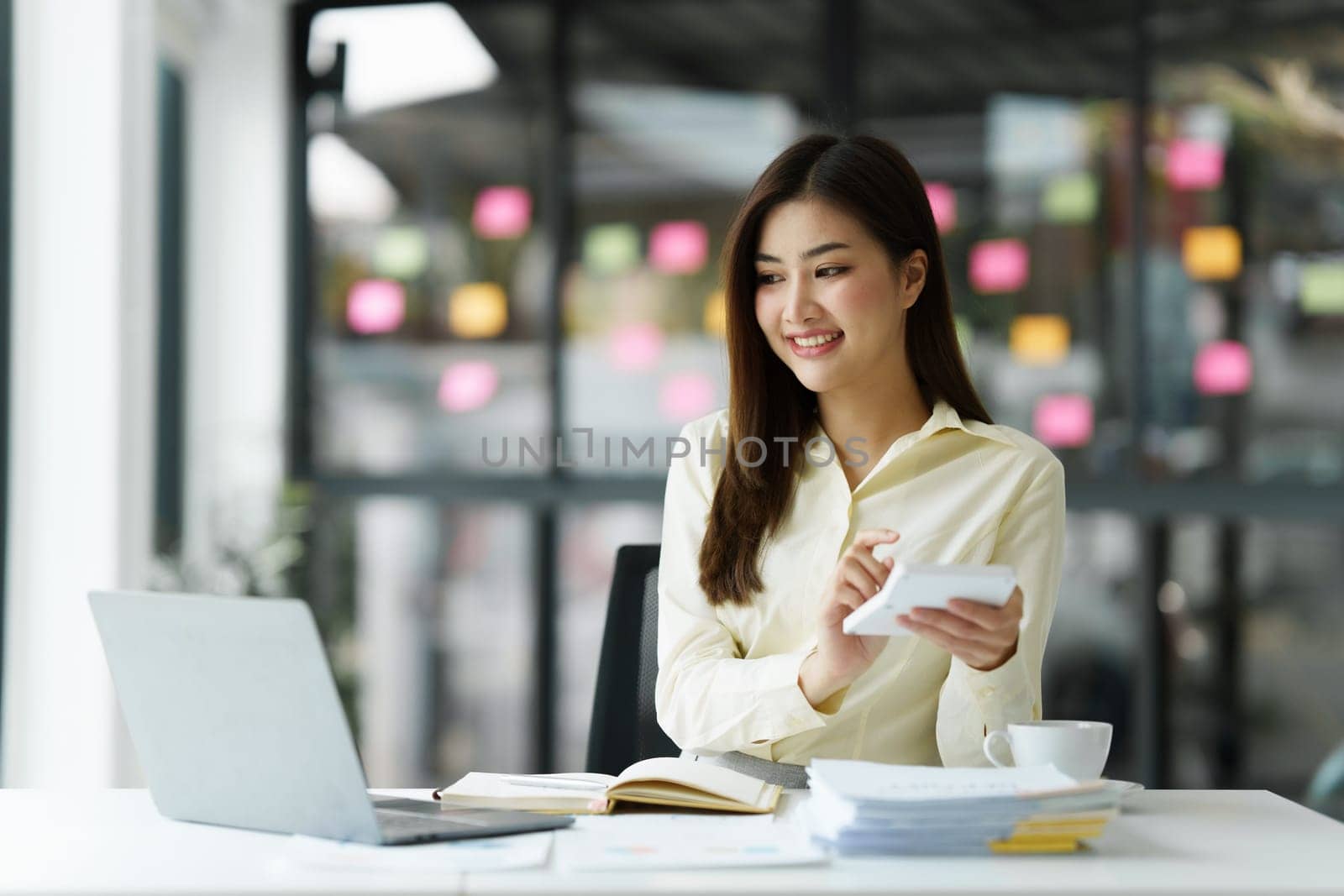Beautiful Asian Banker or Accountant makes financial report and tax, analyzes profits. Accountant checks status of financial.